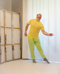 Male choreography in motion in the studio. Young man dancing in a dance studio