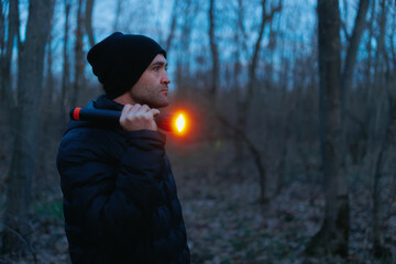 Portrait of a man exploring the nighttime forest with a flashlight