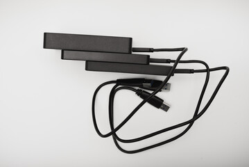 Hard drives on a white background. Modern data storage devices with USB wires.