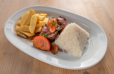 Lomo Saltado traditional Peruvian dish with Chinese influence consisting of beef, rice, fries and vegetables stir fried in a wok