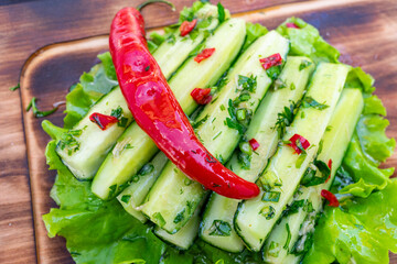 Fresh cucumber salad with chili on a bed of lettuce garnished with herbs