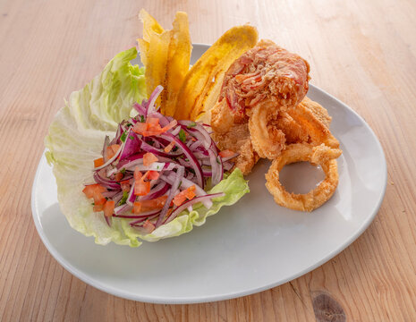 Jalea Mixta Peruvian traditional dish with crispy fried fish, fried yucca and raw vegetables 