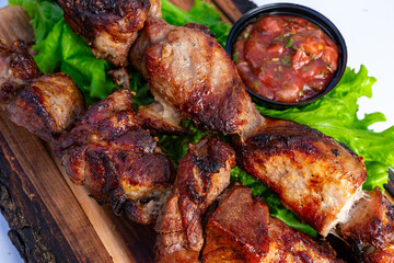 Grilled meat served with fresh salsa on a bed of lettuce