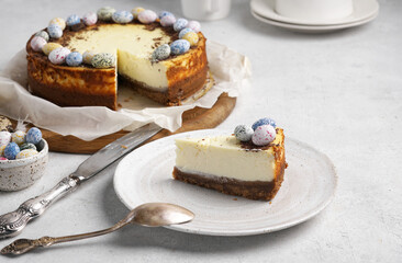 A piece of cheesecake with Easter chocolate eggs, copy space