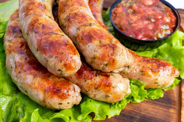 Grilled sausages served with a fresh salsa on a bed of lettuce