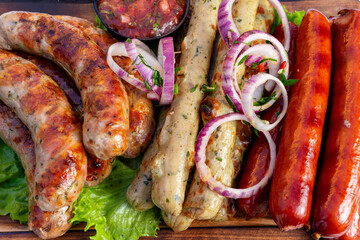 Grilled sausages with fresh vegetables and dipping sauce in a summer picnic
