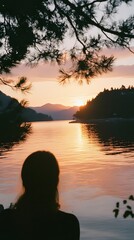 Fototapeta premium The silhouette of trees on the shore, reflecting in the calm waters at sunset 