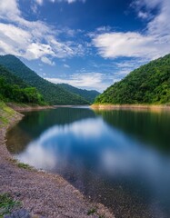 Un hermoso lago en medio de las montañas, con cielo azul y nubes