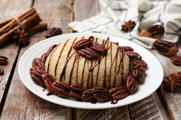 Delicious sweet semolina halva with pecans and spices on wooden table, closeup