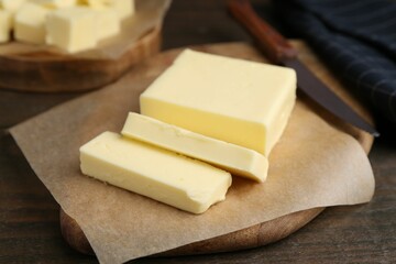 Pieces of fresh butter on wooden table, closeup
