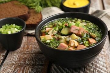 Delicious okroshka soup with kvass and ingredients on wooden table, closeup