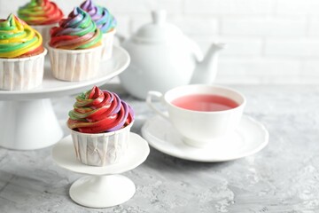 Delicious cupcake with colorful cream on grey textured table, closeup