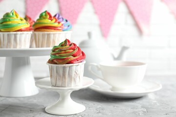 Delicious cupcake with colorful cream on grey textured table, closeup
