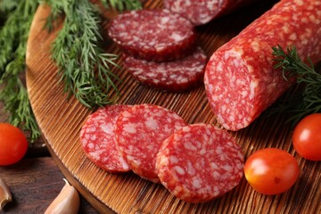 Different smoked sausages, cherry tomatoes and spices on wooden table, closeup