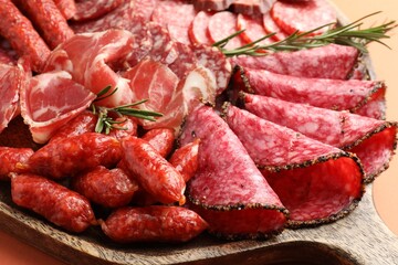 Different smoked sausages slices on orange background, closeup