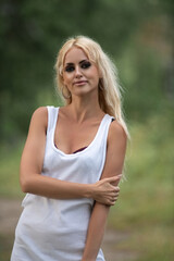 Portrait of a beautiful blonde girl in nature in summer.