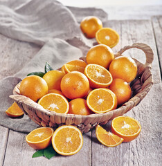 Pomarańcze sokowe w koszyku na tle stołu