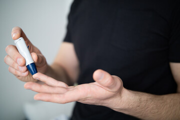 Man using lancet on finger for checking blood sugar level