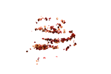 Red chili flakes scattered on a plain background