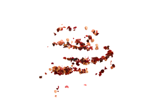 Red chili flakes scattered on a plain background