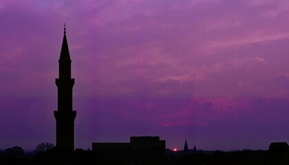 Fototapeta premium Silhouette of slender minaret against fading purple horizon, serenity