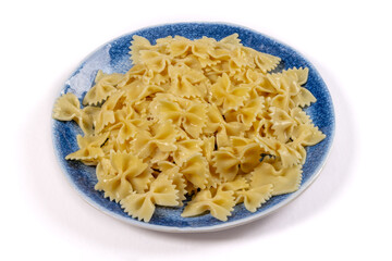 A blue plate of bow tie or farfalle pasta noodles isolated on white