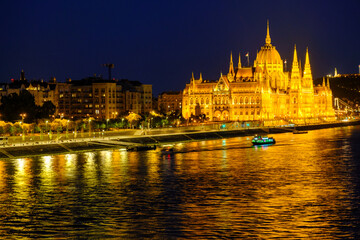 Obraz premium A grand bridge over water with a Budapest's Parliament in the background