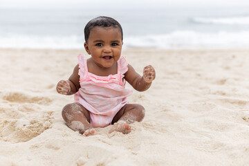 Happy baby girl on her first time at the beach playing. Rio de Janeiro, Brazil.