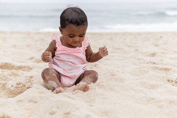 Happy baby girl on her first time at the beach playing. Rio de Janeiro, Brazil.