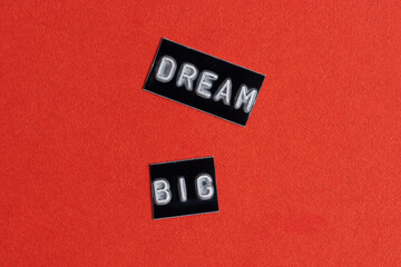 DREAM BIG black text on red paper background. Business concept.