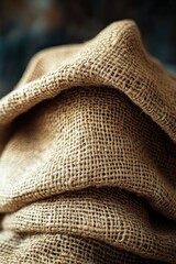 Close up of a coarse burlap fabric, folded in layers with texture visible.