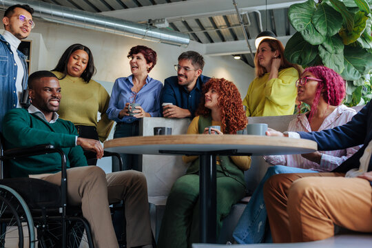 Diverse business team gathering and communicating during office break