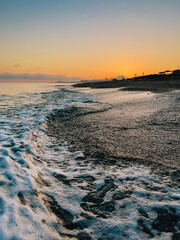 Gentle sea waves washing pebble beach during amazing colorful sunset in Crete, Greece, beautiful...