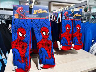 Naklejka premium Kyiv, Ukraine - February 05, 2025: Children's socks featuring Spiderman character design displayed in a clothing store