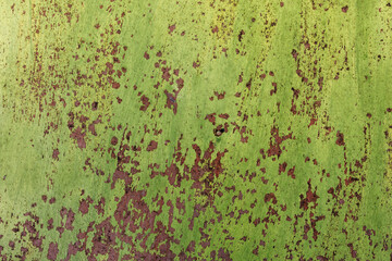Old rusty metal wall painted in green, frontal background texture