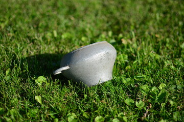 Old soviet style pot with two handles used on furnace. Vintage iron metal dish on green grass.