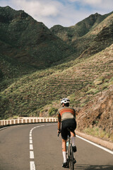 Cyclist rides along scenic mountain road. Stunning landscape and sense of freedom. Perfect for travel, adventure, and healthy lifestyle themes.