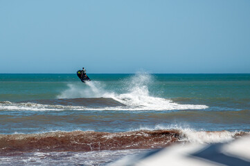 A jet ski jumping over the waves of the sea on a sunny day	