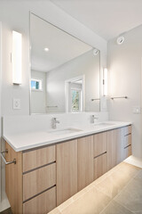 The bathroom is clean and well-lit, with a large mirror above the sink