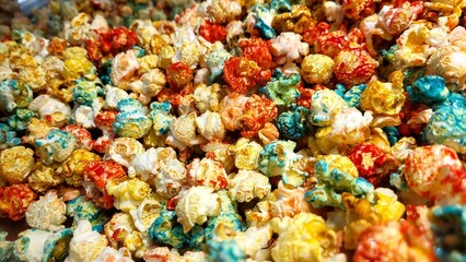 A pile of colorful popcorn with red, yellow, and blue pieces