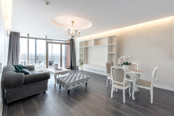 Elegant Modern Home Living Room with Open Kitchen and Stylish Interior Design. Bright and spacious modern living room with dining area and open kitchen, featuring elegant furniture and tasteful decor.