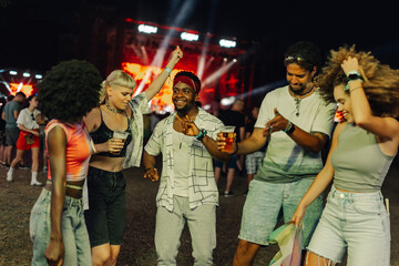 Friends enjoying live music and dancing at summer festival