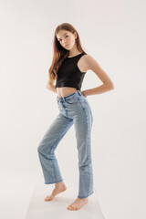 Young model poses confidently in stylish outfit against plain background