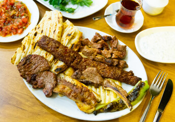 Roasted red meat served on plate with flatbread and grilled pepper.