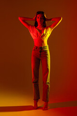 Stylish model poses dramatically in vibrant lighting during a creative indoor photoshoot