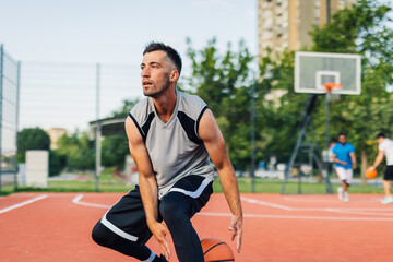 Fototapeta premium Basketball player dribbling on outdoor court