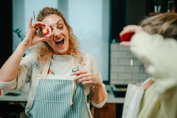Fototapeta premium Woman showing painted easter egg and having fun with her daughter