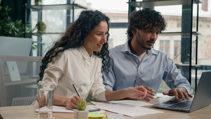 Arabian female employer insurance agent consult Indian male client discuss business project finance marketing data on laptop two multiracial businesswoman and businessman corporate teamwork e-commerce