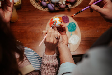 Fototapeta premium Hands creating colorful easter egg art