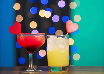 Glasses of cocktails with valentines decoration on bokeh lights background